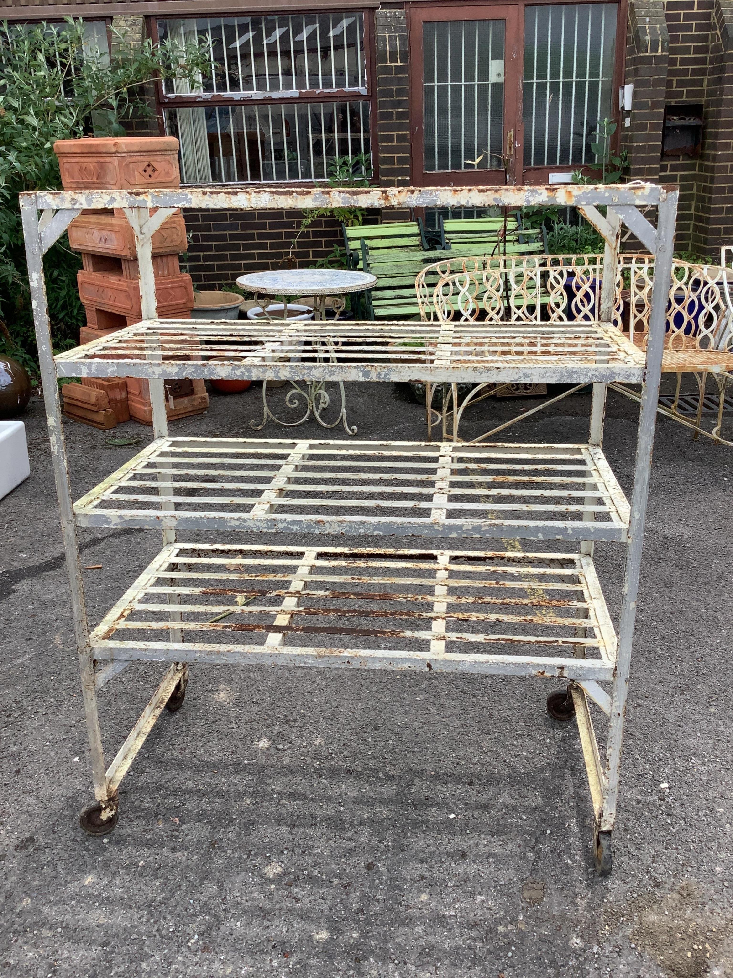 A painted wrought iron four tier pot stand, width 100cm, depth 51cm, height 123cm